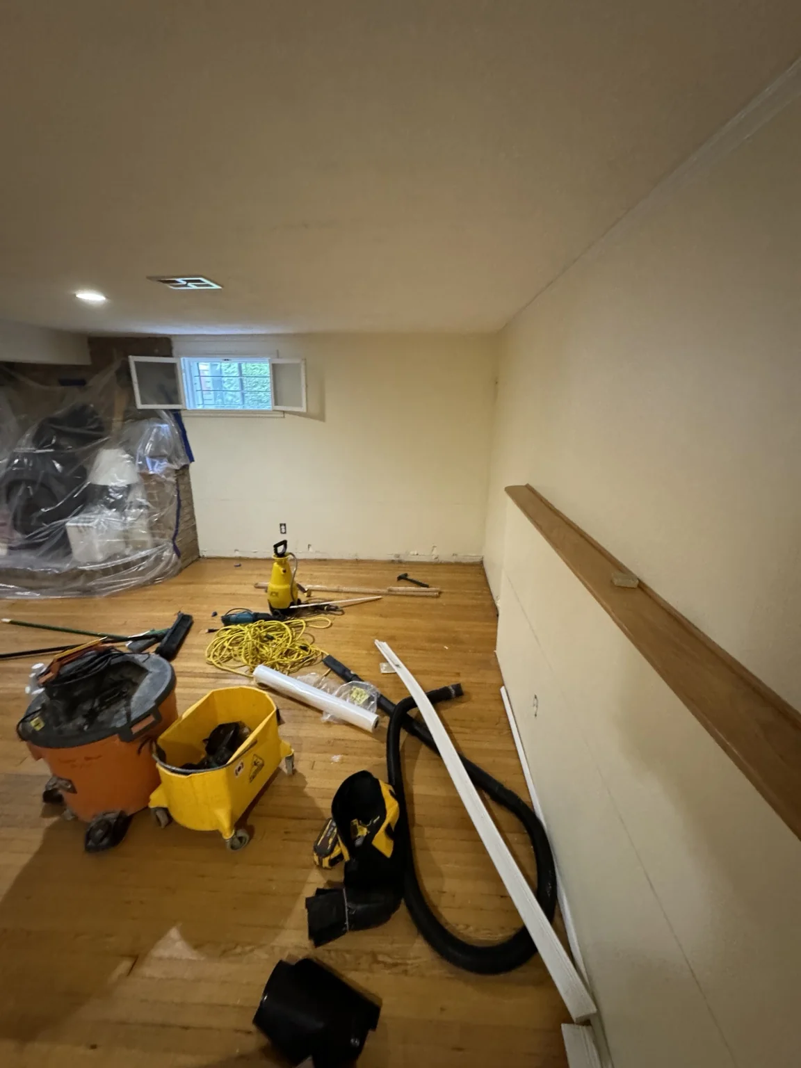 Basement with exposed floor and tools during flooring work